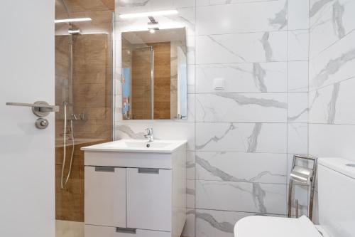 bagno bianco con lavandino e doccia di Apartamentos Old Town by Umbral ad Albufeira