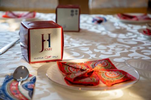 فندق جوري المشاعر في مكة المكرمة: طاولة مع صحن مع صندوق وملعقة