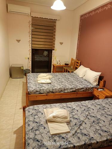 a hotel room with two beds and a table at Georgios Rooms in Kalabaka