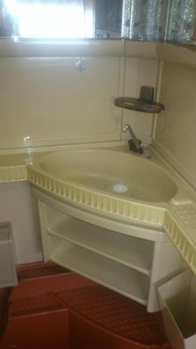 a bathroom with a bath tub with a sink at Summer bungalo trailer in Jūrmala