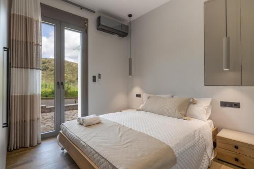 a bedroom with a bed and a large window at Otium Residence in Kouvaláta