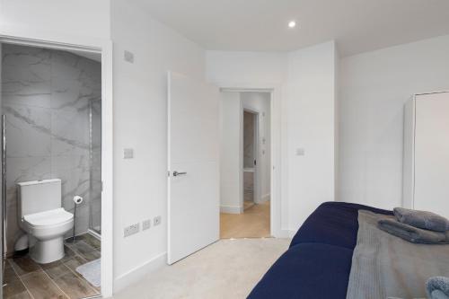 a white bedroom with a bed and a toilet at Star London Station Road 2-Bed Retreat with Garden in London