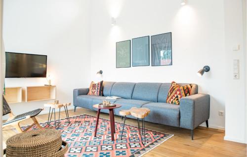 a living room with a blue couch and a rug at Nice Home In Lembruchdümmer See in Lembruch