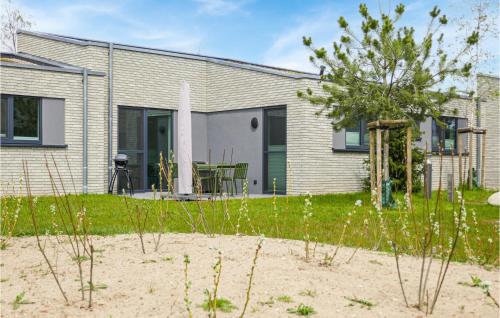 a house on the beach with a tree in the yard at Nice Home In Lembruchdümmer See in Lembruch