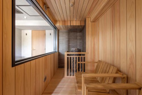 a room with wooden walls and a staircase with two wooden chairs at TheMana Village in Tosashimizu