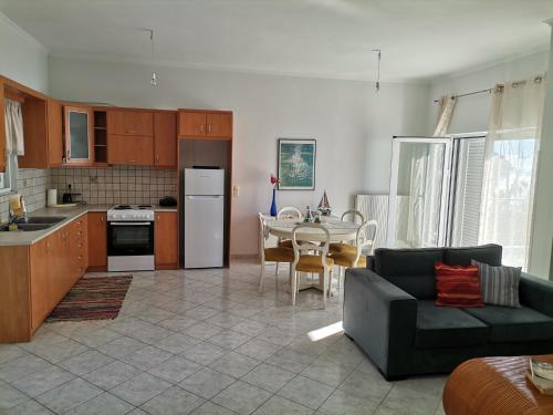 eine Küche und ein Wohnzimmer mit einem Sofa und einem Tisch in der Unterkunft Διαμέρισμα Παραλία Μενιδίου in Menídion