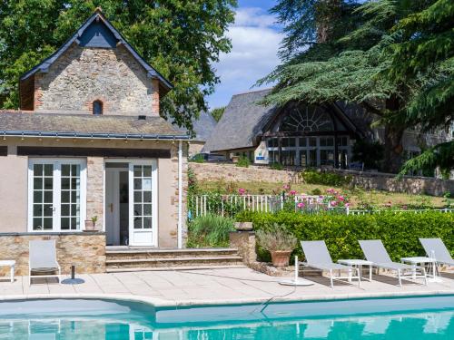 une maison avec une piscine en face d'une maison dans l'établissement Château De Noirieux, à Briollay