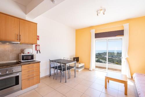 アルブフェイラにあるVista Albufeira Apartments by Umbralのテーブル付きのキッチン、窓付きのキッチンが備わります。