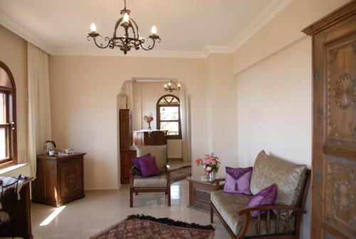 a living room with a chandelier and purple pillows at Mandarin & Mango Boutique Hotel in Faralya