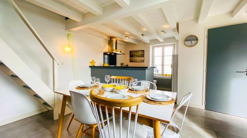 une cuisine et une salle à manger avec une table et des chaises dans l'établissement Charmante villa dans le centre du village, au Bois-Plage-en-Ré