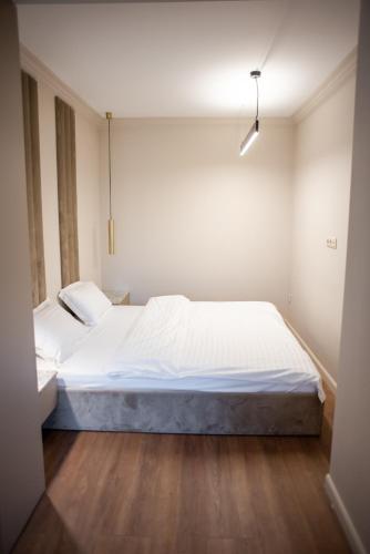 a bedroom with a large white bed in it at Opera Apartments in Cluj-Napoca