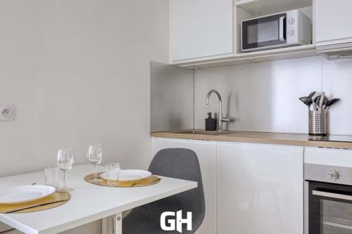 une cuisine avec une table et deux assiettes et des verres dans l'établissement Le Season - Bel appartement - Proche Disney & Paris RER E, à Villiers-sur-Marne