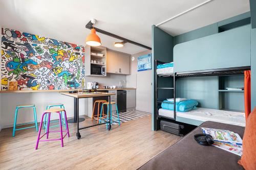 um quarto com uma secretária e um beliche em travelski home select - Résidence & Hostel Yoonly & Friends em Risoul