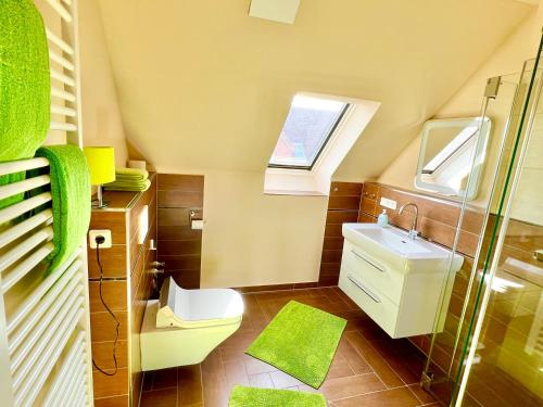 ein Bad mit einem WC, einem Waschbecken und einem Fenster in der Unterkunft SONNIGE KUSCHELZEIT in Niebüll