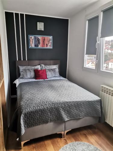 ein Schlafzimmer mit einem großen Bett mit roten Kissen in der Unterkunft Apartment Melli in Sarajevo