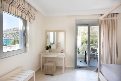 a bedroom with a desk and a view of a balcony at Almiriki Chios Rooms & Apartments in Líthion