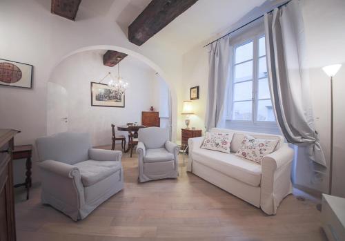 ein Wohnzimmer mit einem weißen Sofa und 2 Stühlen in der Unterkunft Apartments Florence Parione in Florenz