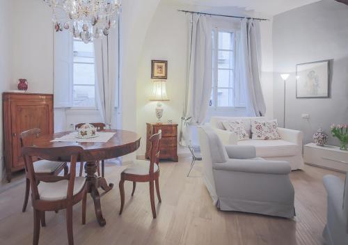 sala de estar con mesa y sofá blanco en Apartments Florence Parione, en Florencia