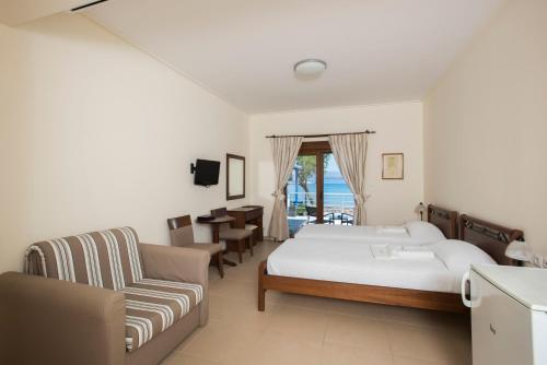 a bedroom with a bed and a couch and a chair at Almiriki Chios Rooms & Apartments in Líthion