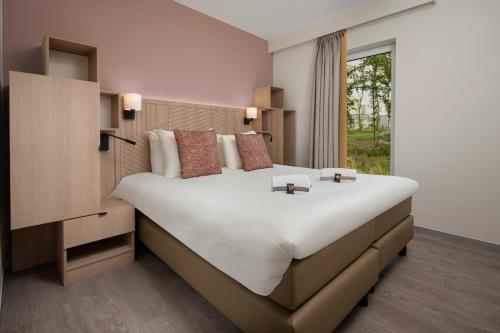 - une chambre avec un grand lit et une fenêtre dans l'établissement Terhills Resort by Center Parcs, à Dilsen-Stokkem