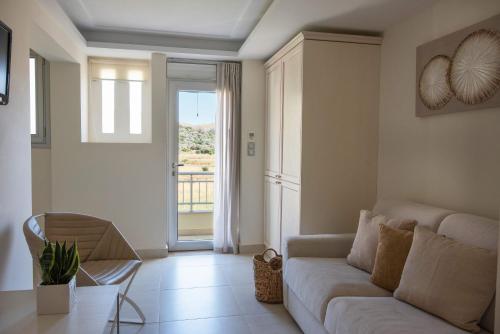 a living room with a couch and a sliding glass door at Almiriki Chios Rooms & Apartments in Líthion