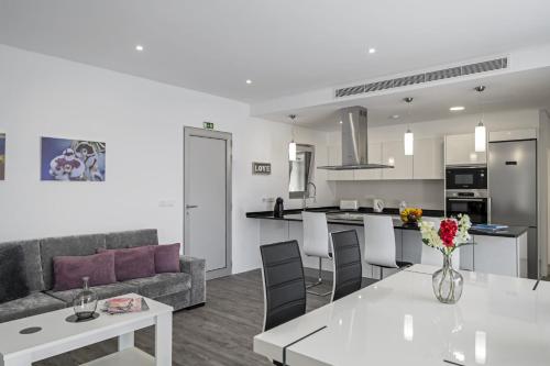 a living room and kitchen with a couch and a table at Villa Calhetascape by Villa Plus in Estreito da Calheta