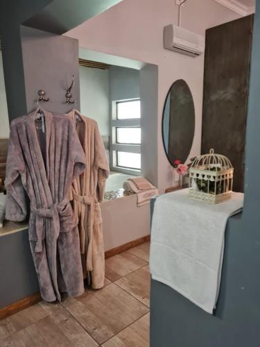 a bathroom with a towel on a rack and a mirror at Little Rock Resort in Ladybrand