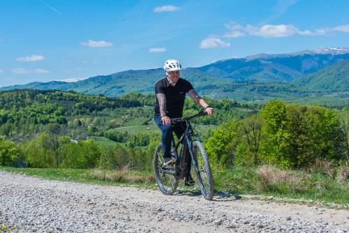 a man riding a bike on a gravel road at Pensiunea Runcu Stone in Piatra