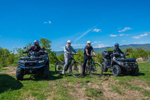 a group of people with bikes and atvs on a field at Pensiunea Runcu Stone in Piatra