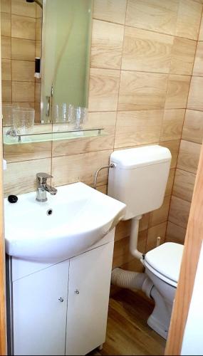 a bathroom with a white sink and a toilet at MP Center Magánszállás in Miskolc