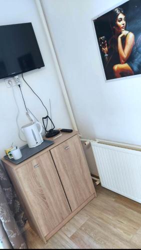 a tv on top of a wooden cabinet in a room at MP Center Magánszállás in Miskolc
