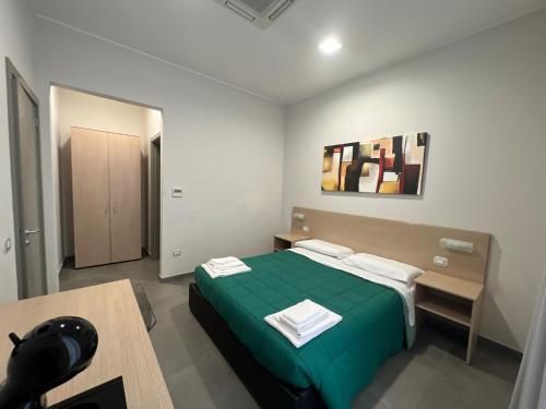 Un dormitorio con una cama verde y una mesa en Palazzo 41 Rental Rooms, en San Pietro Vernotico