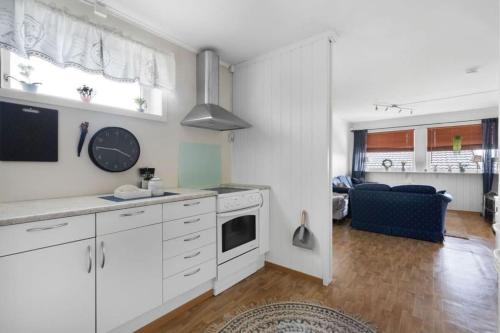 a kitchen with white cabinets and a living room at Apartment, 4km fra Tromsøsentrum. flyplass 1.71km. in Tromsø