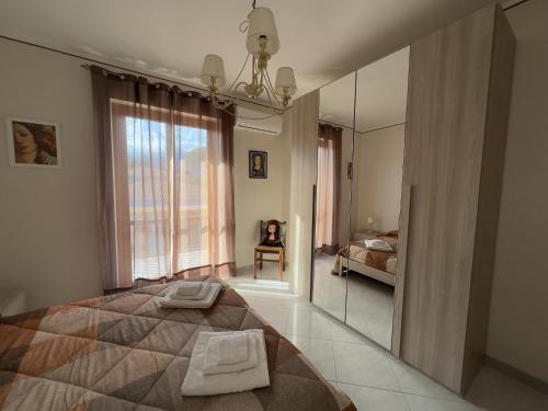 a bedroom with a large bed and a mirror at La pigna delle Aci Apartment in Acireale