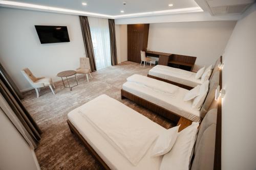 a hotel room with two beds and a dining room at Hotel Ariata in Scheia