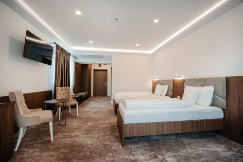 a hotel room with two beds and a table at Hotel Ariata in Scheia