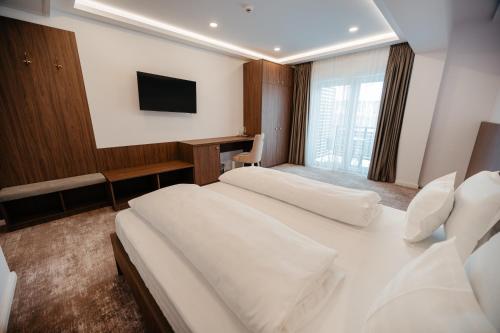 a hotel room with a bed and a television at Hotel Ariata in Scheia