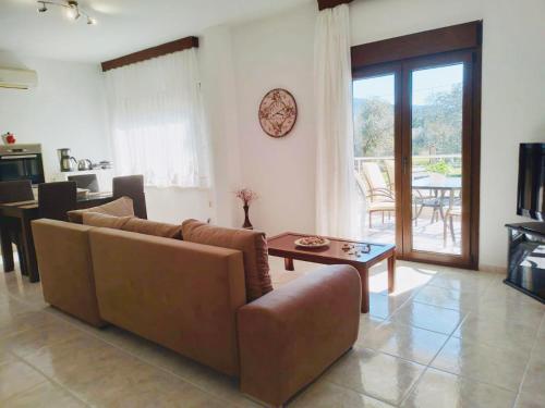 a living room with a couch and a table at Villa Calypso in Skala Rachoniou