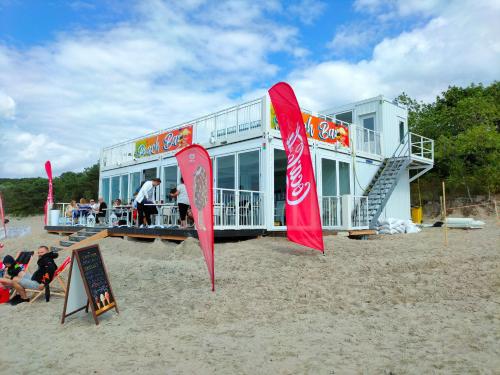 a building on the beach with red flags in the sand at Villa Martini in Międzyzdroje