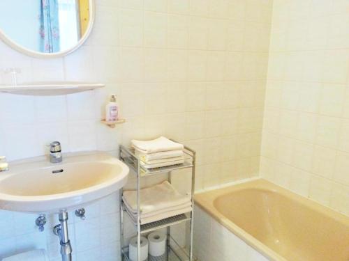 een badkamer met een wastafel, een bad en een spiegel bij Gasthof Dürregger in Leiben