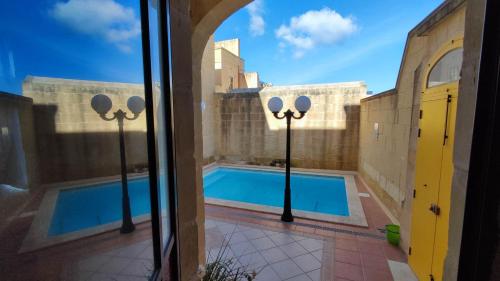 a view of a swimming pool from a building at Qala Bed&Breakfast with swimming pool - IL-Wenniessa in Qala