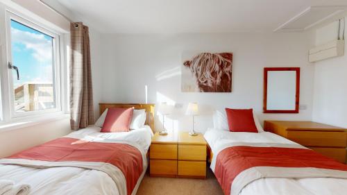 two beds in a room with a window at Barker Stakes Farm in Pickering