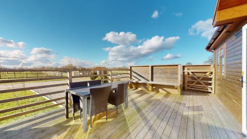 a wooden deck with a table and chairs on it at Barker Stakes Farm in Pickering