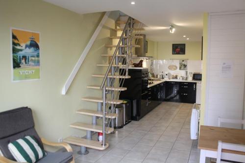 une cuisine avec un escalier en colimaçon dans le salon dans l'établissement L'Escale VICHY, à Vichy