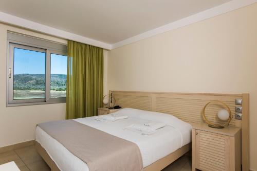 a bedroom with a white bed and a window at Almiriki Chios Rooms & Apartments in Líthion