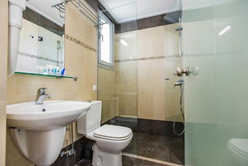 a bathroom with a toilet and a sink and a shower at Almiriki Chios Rooms & Apartments in Líthion