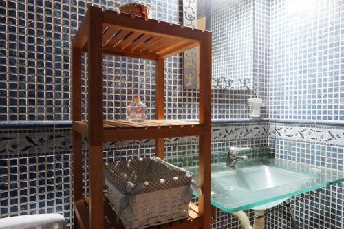 Baño de azulejos azules con lavabo y espejo en CAL XECARMA en Tordera