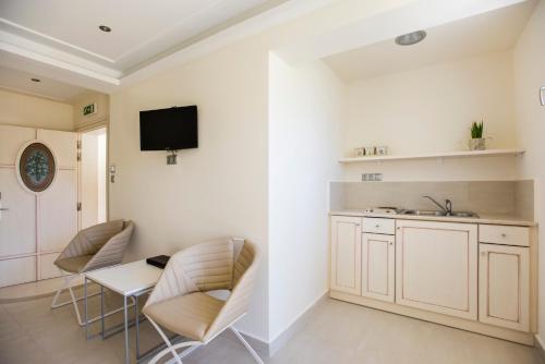 a kitchen with two chairs and a table and a sink at Almiriki Chios Rooms & Apartments in Líthion