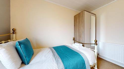 a bedroom with a bed with a blue pillow and a mirror at Barker Stakes Farm in Pickering