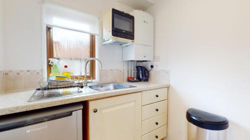 a small kitchen with a sink and a microwave at Barker Stakes Farm in Pickering